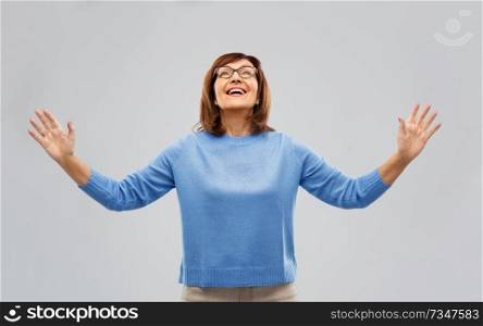 happiness and old people concept - happy senior woman looking up thanks god over grey background. happy senior woman looking up thanks god