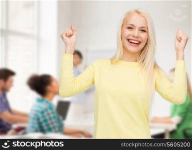 happiness and people concept - laughing young woman with hands up