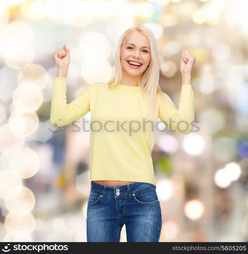 happiness and people concept - laughing young woman with hands up