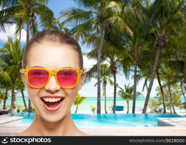 happiness and people concept - portrait of happy teenage girl in pink sunglasses