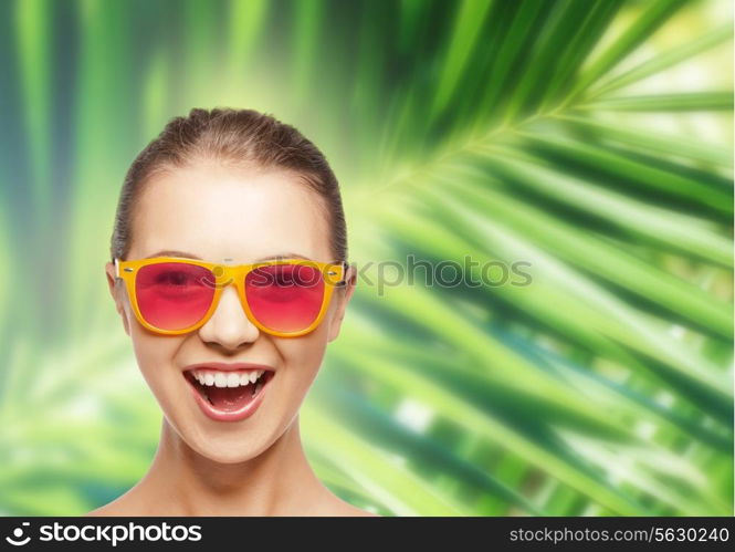 happiness and people concept - portrait of happy teenage girl in pink sunglasses