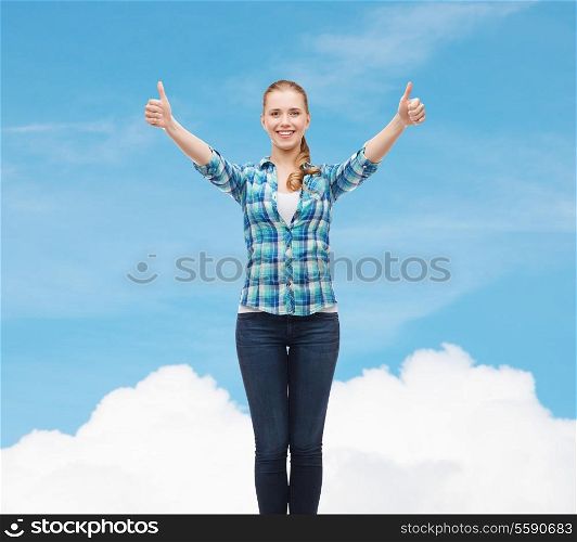 happiness and people concept - smiling girl in casual clothes showing thumbs up over blue sky background