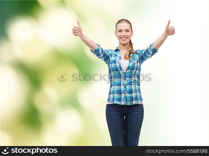 happiness and people concept - smiling girl in casual clothes showing thumbs up over green background
