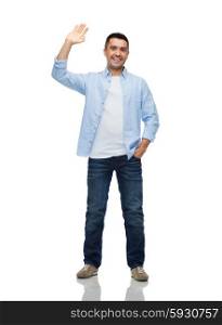 happiness and people concept - smiling man in shirt and jeans waving hand. smiling man waving hand