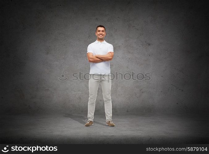 happiness and people concept - smiling man in white t-shirt with crossed arms over concrete background