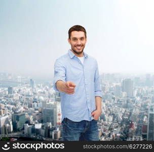 happiness and people concept - smiling man pointing finger at you