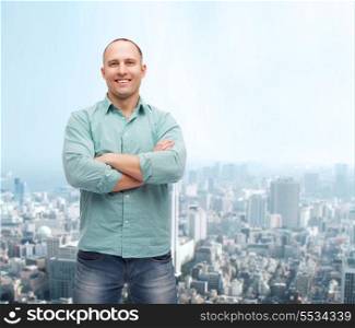 happiness and people concept - smiling man with crossed arms