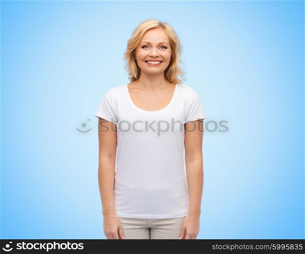 happiness and people concept - smiling middle aged woman in blank white t-shirt over blue background. smiling middle aged woman in blank white t-shirt