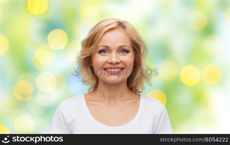 happiness and people concept - smiling woman in blank white t-shirt over green summer lights background. smiling woman in blank white t-shirt