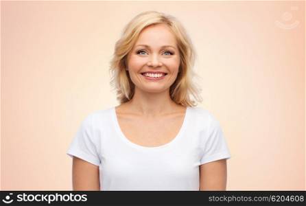 happiness and people concept - smiling woman in blank white t-shirt over beige background. smiling woman in blank white t-shirt