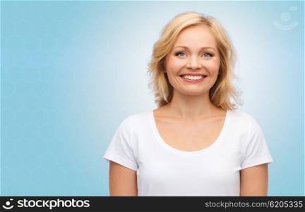 happiness and people concept - smiling woman in blank white t-shirt over blue background. smiling woman in blank white t-shirt