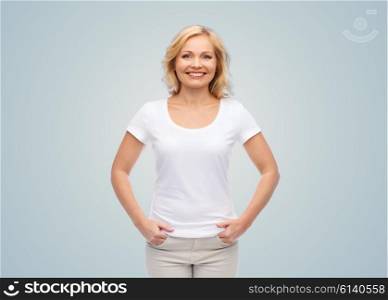 happiness and people concept - smiling woman in blank white t-shirt over gray background. smiling woman in blank white t-shirt