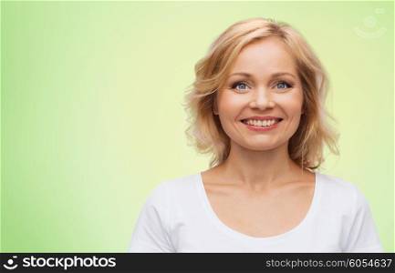 happiness and people concept - smiling woman in blank white t-shirt over green natural background. smiling woman in blank white t-shirt