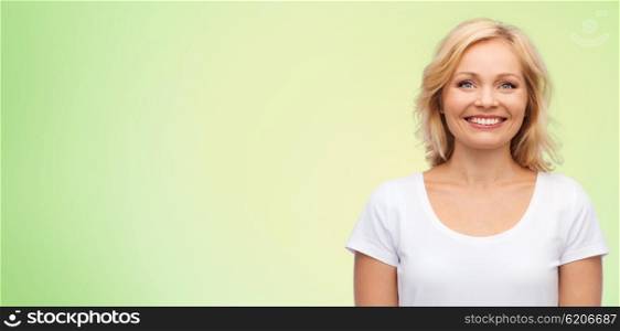 happiness and people concept - smiling woman in blank white t-shirt over green natural background. smiling woman in blank white t-shirt