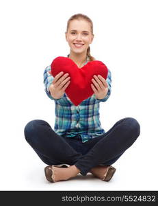 happiness and people concept - smiling young woman in casual clothes sitiing on floor and holding red heart