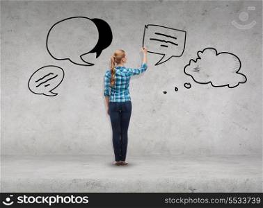 happiness and people concept - smiling young woman writing or drawing text bubbles on virtual screen