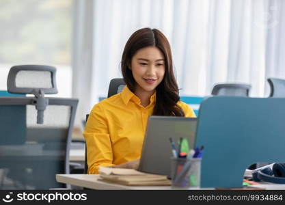 Happiness Attractive Asian woman in yellow shirt working with computer laptop thinking to get ideas and requirement in Business startup at modern office or Co-working space,Business Startup Concept