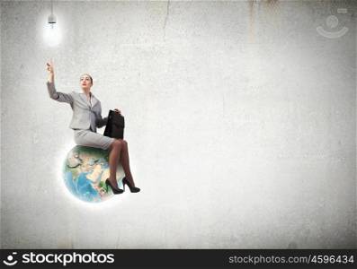 Happiness businesswoman sit on top of Earth planet. Elements of this image are furnished by NASA. On top of world