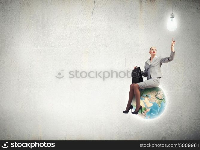 Happiness businesswoman sit on top of Earth planet. Elements of this image are furnished by NASA. On top of world