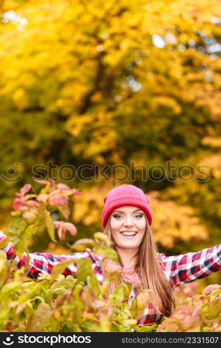 Happiness carefree. woman relaxing in autumn park throwing leaves up in the air with arms raised up. Beautiful girl in colorful forest foliage outdoor.