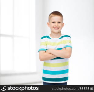 happiness, childhood and people concept - smiling little boy in casual clothes with crossed arms over white room background