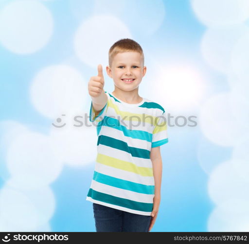 happiness, childhood and people concept - smiling little boy in casual clothes with showing thumbs up over blue background