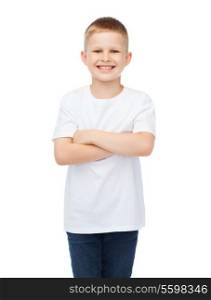 happiness, childhood and people concept - smiling little boy in white t-shirt with his arms crossed