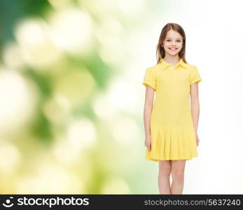 happiness, childhood and people concept - smiling little girl in yellow dress