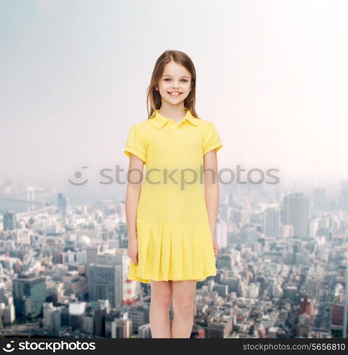 happiness, childhood and people concept - smiling little girl in yellow dress