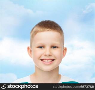 happiness, childhood, dreams and people concept - smiling little boy over blue cloudy sky background
