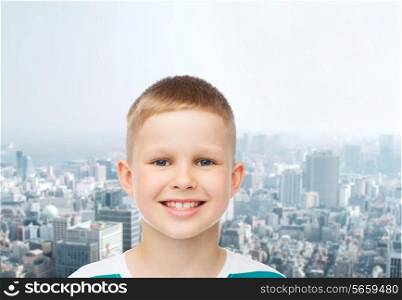 happiness, childhood, dreams and people concept - smiling little boy over green blue cloudy sky background