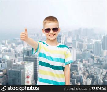 happiness, childhood, dreams and people concept - smiling little boy over green blue cloudy sky background