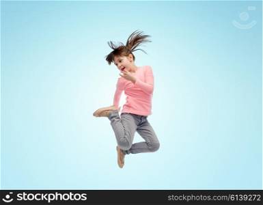 happiness, childhood, freedom, movement and people concept - happy little girl jumping in air over blue background