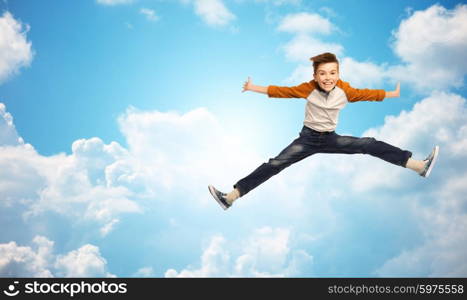 happiness, childhood, freedom, movement and people concept - happy smiling boy jumping in air over blue sky and clouds background