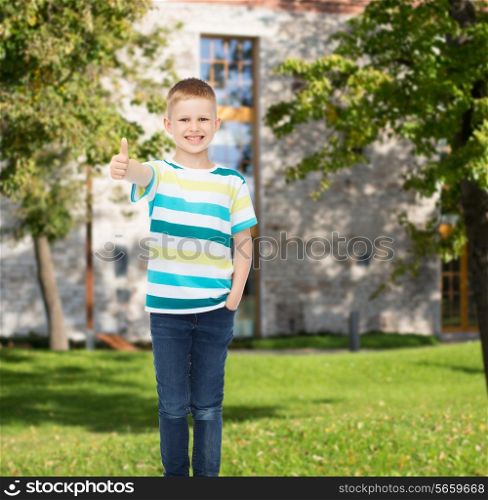 happiness, childhood, gesture, leisure and people concept - smiling little boy in casual clothes showing thumbs up over campus background