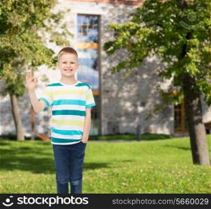 happiness, childhood, gesture, leisure and people concept - smiling little boy in casual clothes showing ok sign over campus background