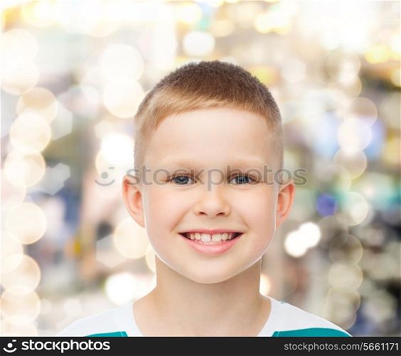 happiness, childhood, holidays and people concept - smiling little boy over sparkling background