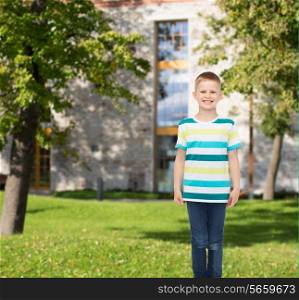 happiness, childhood, leisure and people concept - smiling little boy in casual clothes over campus background