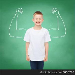 happiness, childhood, school education, advertisement and people concept - smiling little boy in white t-shirt over green board background strong arms drawing