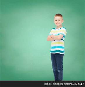 happiness, childhood, school, education and people concept - smiling little boy in casual clothes over green board background