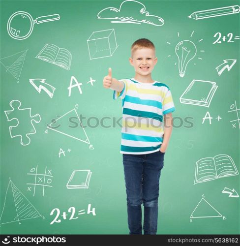happiness, childhood, school, education and people concept - smiling little boy showing thumbs up over green board with doodles background