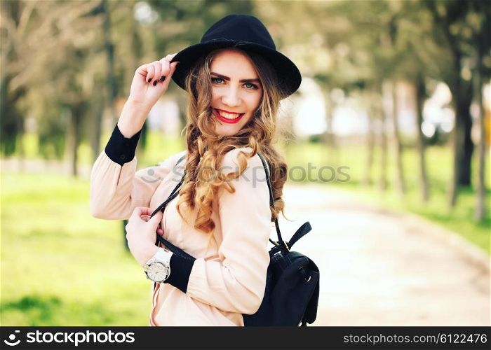 Happiness, consumerism, fashion and people concept - smiling young trendy hipster girl on city background in the sunlight outdoor