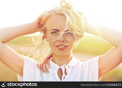 happiness, country, summer holidays, vacation and people concept - close up of happy smiling young woman or teenage girl with wild hair outdoors. close up of happy young woman in white outdoors. close up of happy young woman in white outdoors