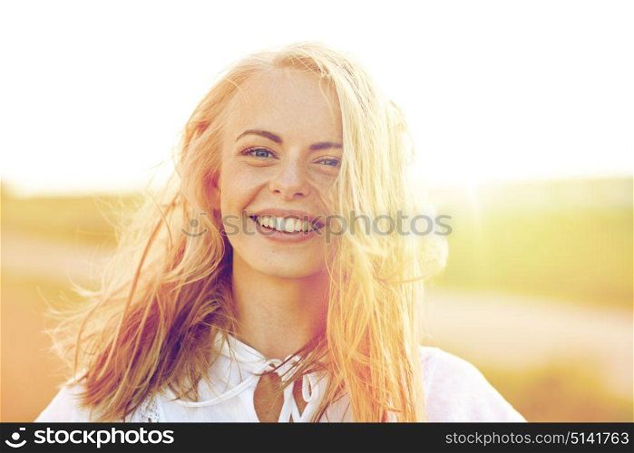 happiness, country, summer holidays, vacation and people concept - close up of happy smiling young woman or teenage girl with wild hair outdoors. close up of happy young woman in white outdoors