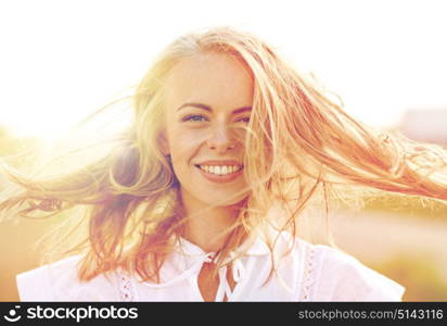 happiness, country, summer holidays, vacation and people concept - close up of happy smiling young woman or teenage girl with wild hair outdoors. close up of happy young woman in white outdoors