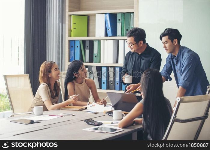 Happiness diversity business team meeting corporate office desk in company meeting room. Asian team group partner brainstorming discussion multiethnic people sitting share ideas teamwork in boardroom
