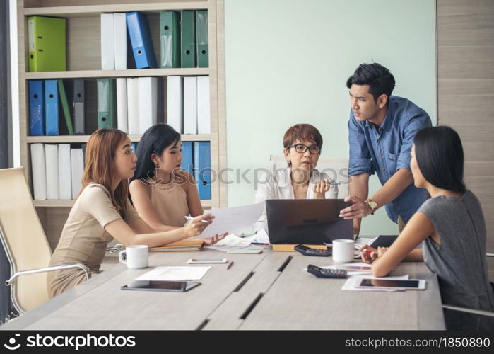 Happiness diversity business team meeting corporate office desk in company meeting room. Asian team group partner brainstorming discussion multiethnic people sitting share ideas teamwork in boardroom