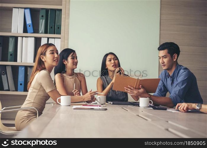 Happiness diversity business team meeting corporate office desk in company meeting room. Asian team group partner brainstorming discussion multiethnic people sitting share ideas teamwork in boardroom