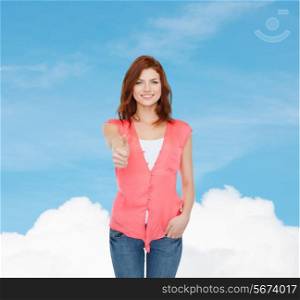 happiness, dream, gesture and people concept - smiling teenage girl in casual clothes showing thumbs up over blue sky background