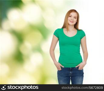 happiness, ecology, advertisement and people concept - smiling teenage girl in casual clothes over green background
